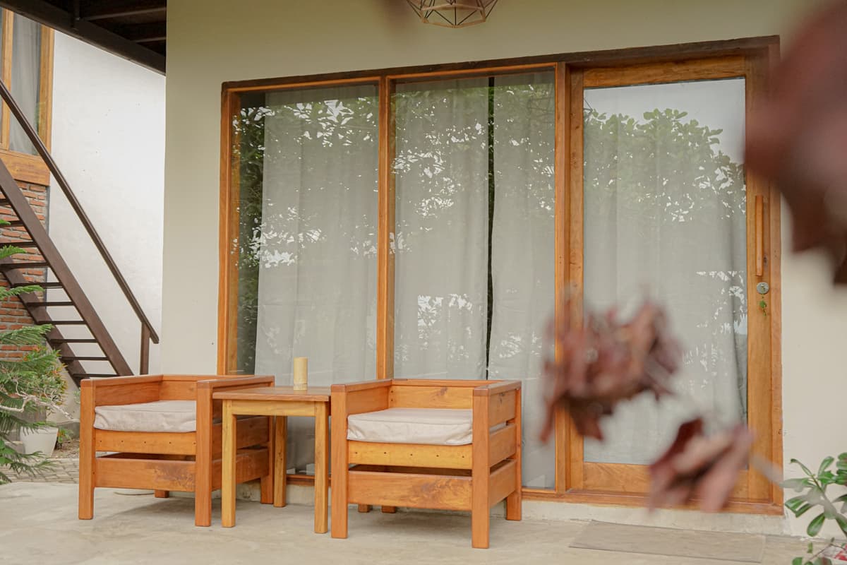 Two wooden armchairs on the Kapas terrace outside the sliding glass doors